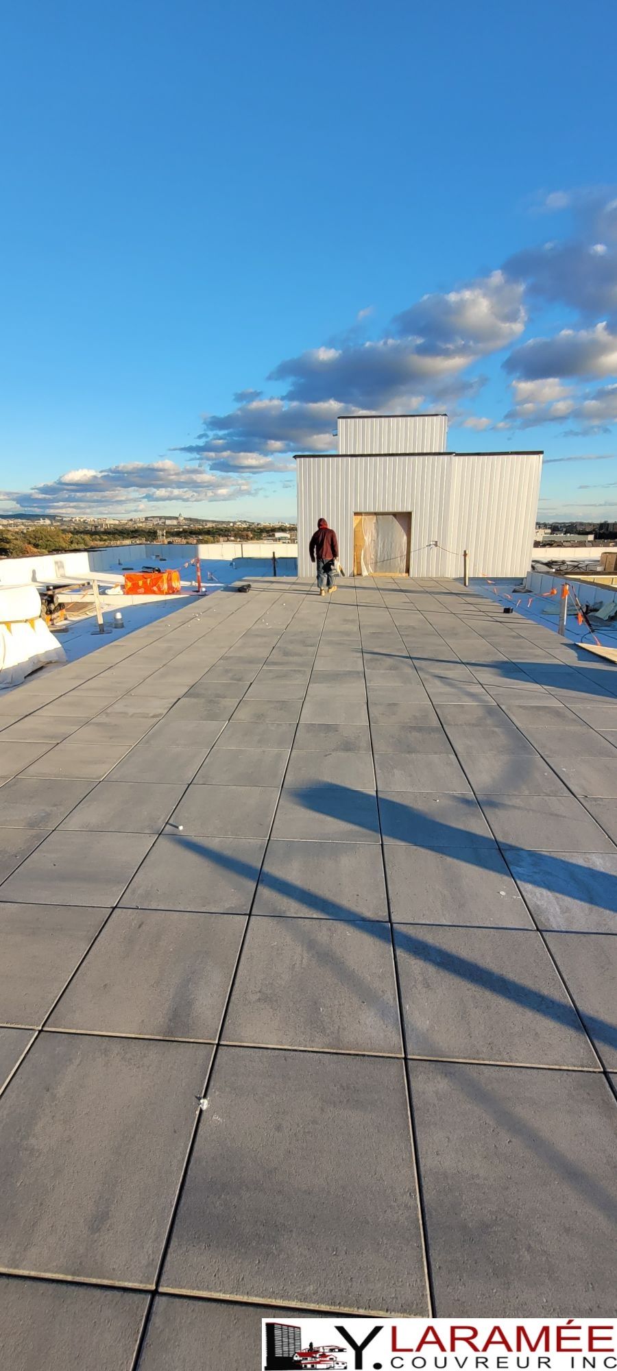 Un homme marche sur le toit d'un immeuble.