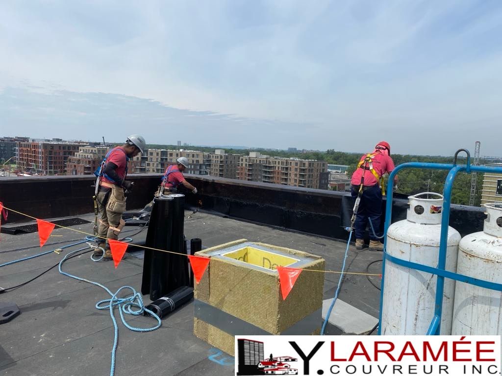 Un groupe d'ouvriers du bâtiment travaille sur un toit