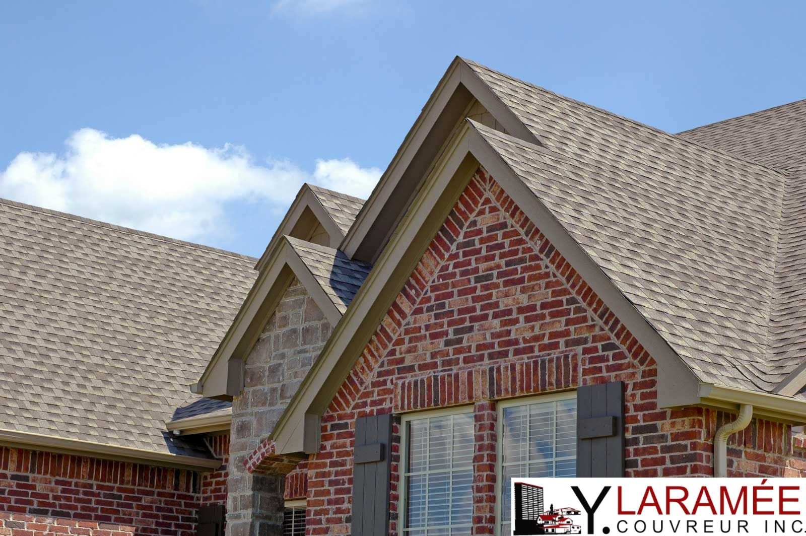 Une maison en briques avec un toit recouvert de bardeaux