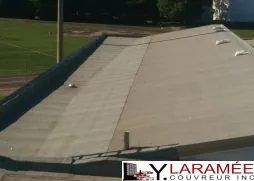 Le toit d'un bâtiment avec un terrain de baseball en arrière-plan.