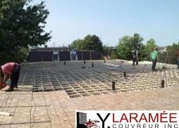 Un groupe de personnes travaille sur un toit.