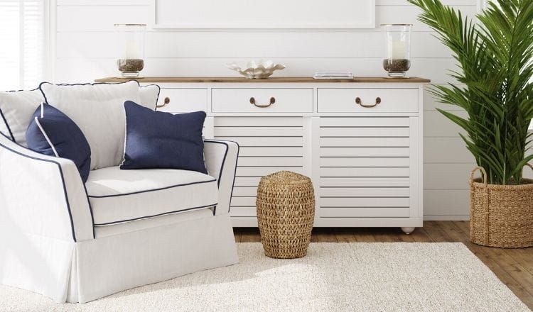 A living room with a white chair and a white dresser.