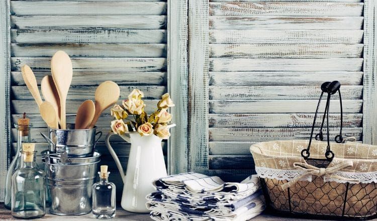A table with a vase of flowers and utensils on it.