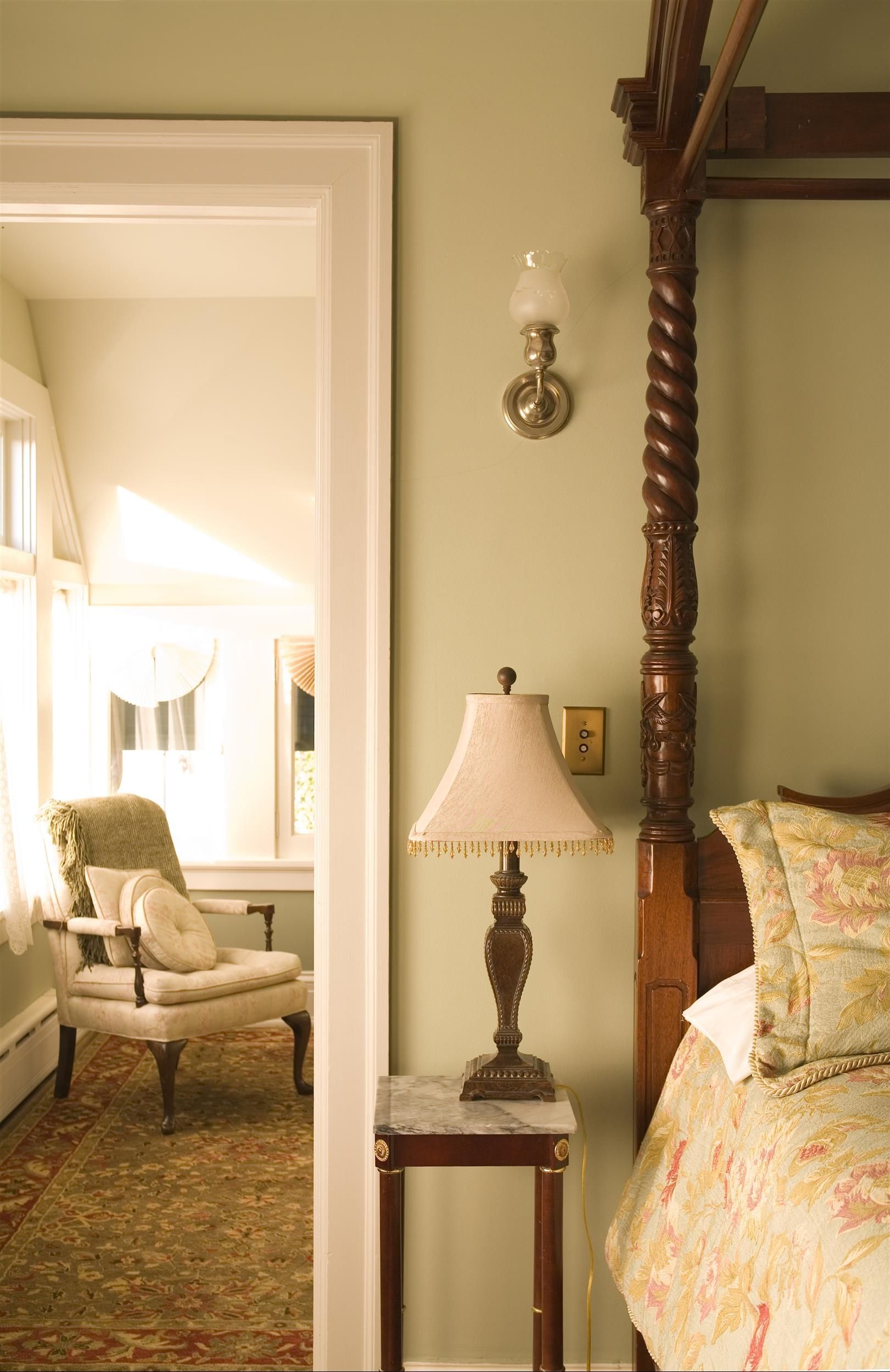 A bedroom with a canopy bed and a lamp