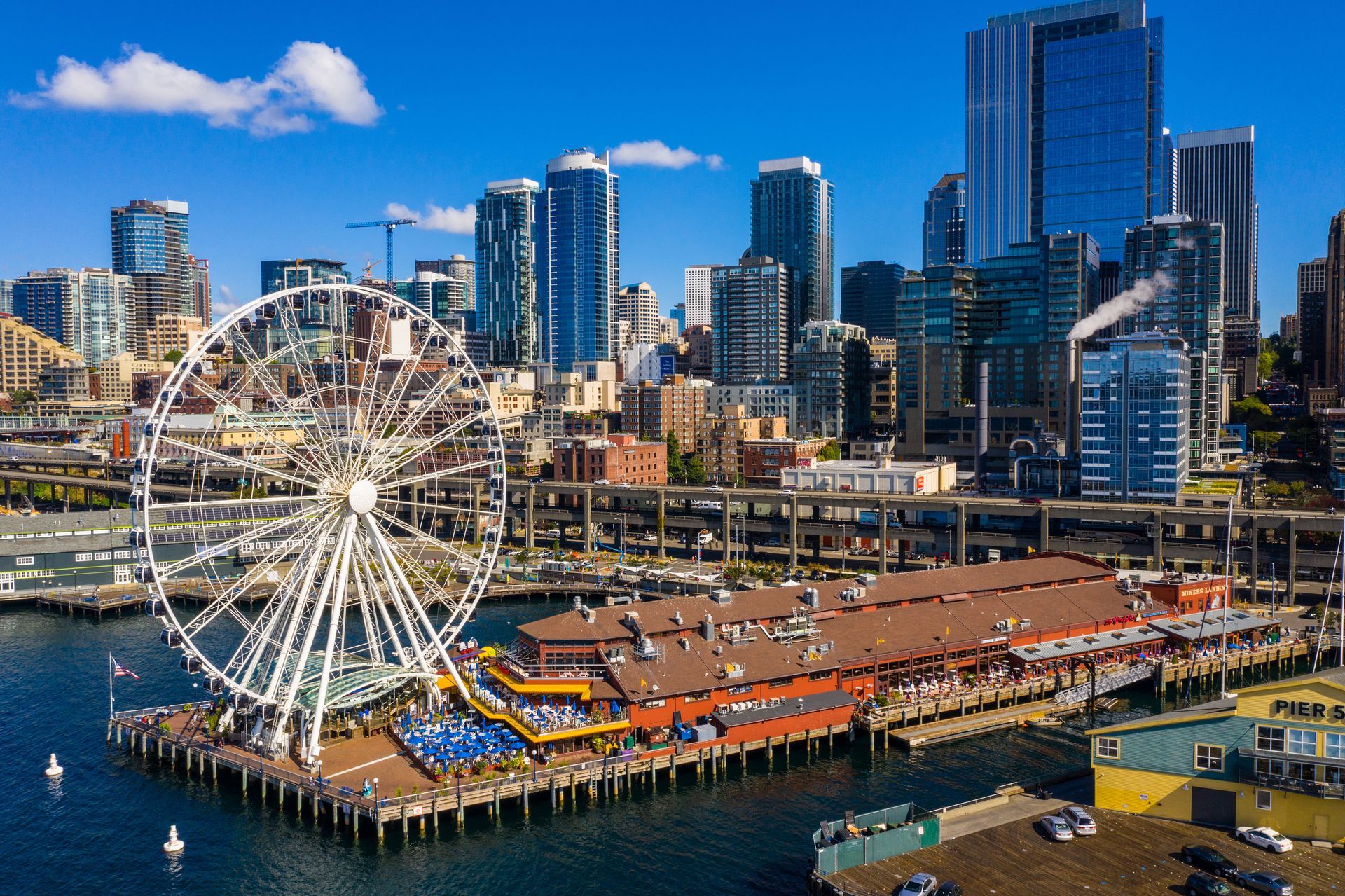 An aerial view of a city with a ferris wheel in the foreground.