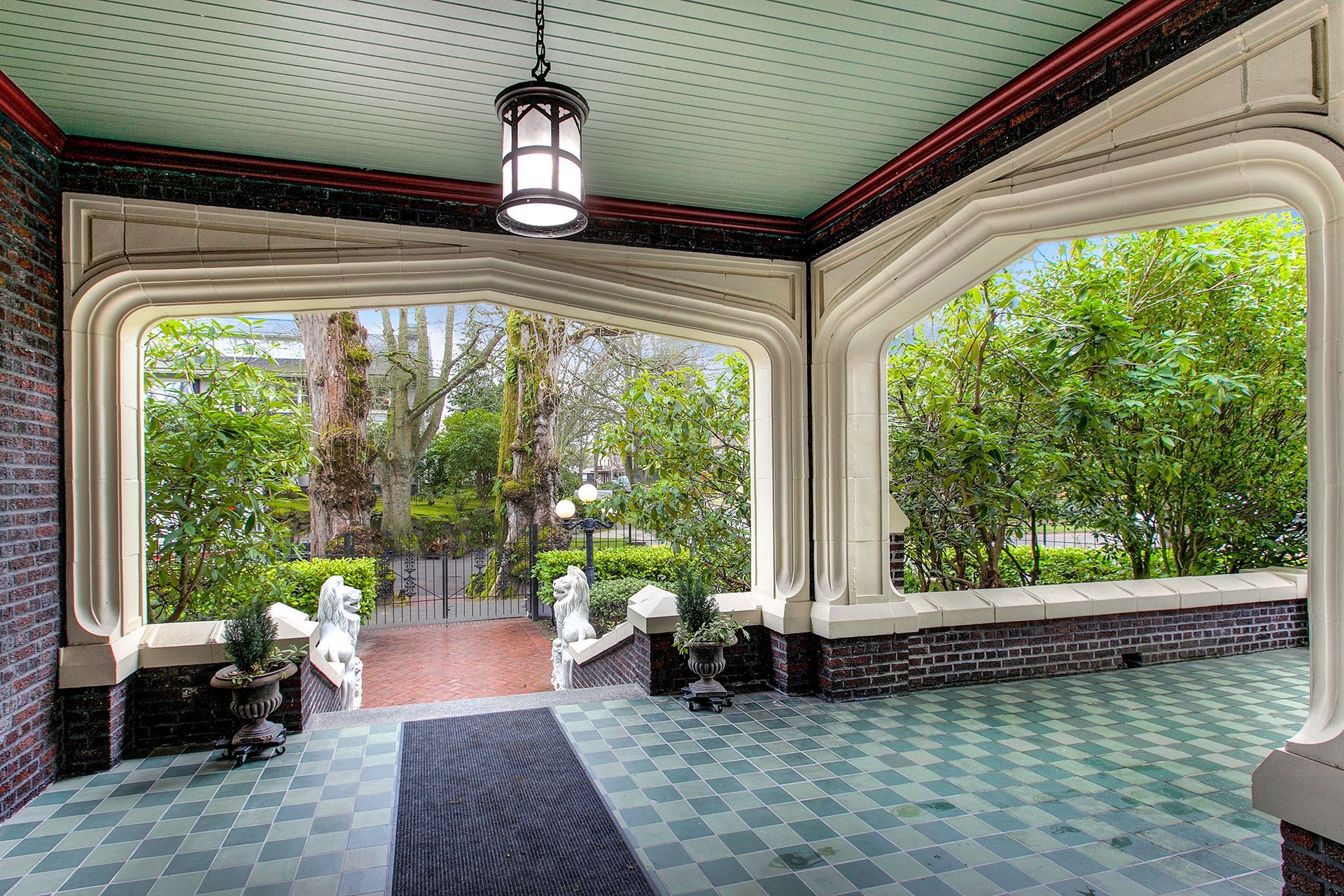 A porch with a checkered floor and a lantern hanging from the ceiling.