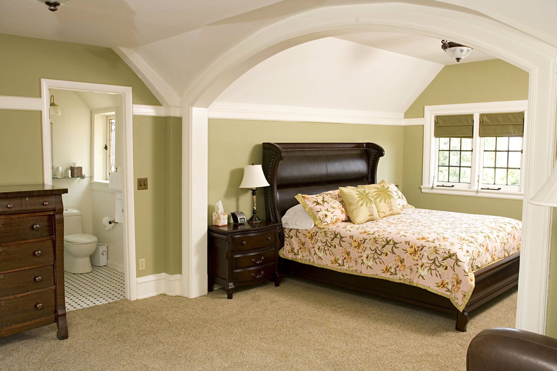 A bedroom with a large bed and a dresser