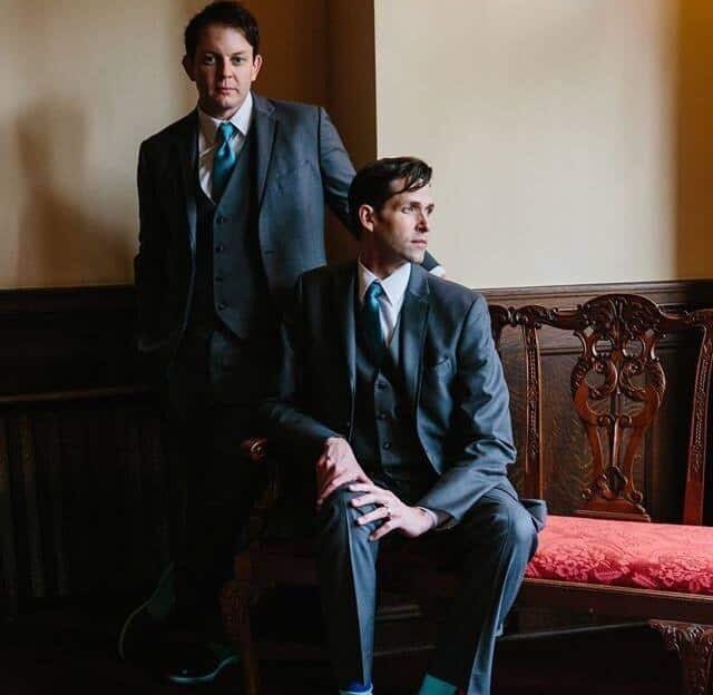 Two men in suits and ties are standing next to each other