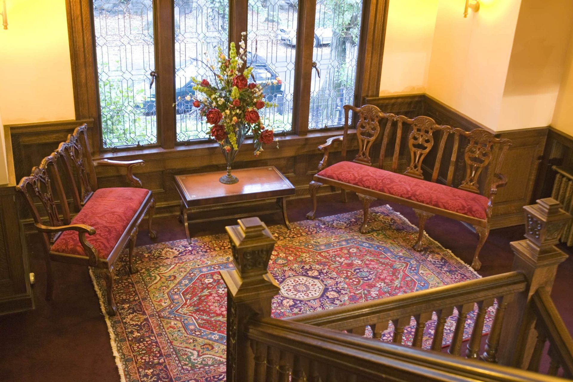 A living room with a couch a table and a vase of flowers