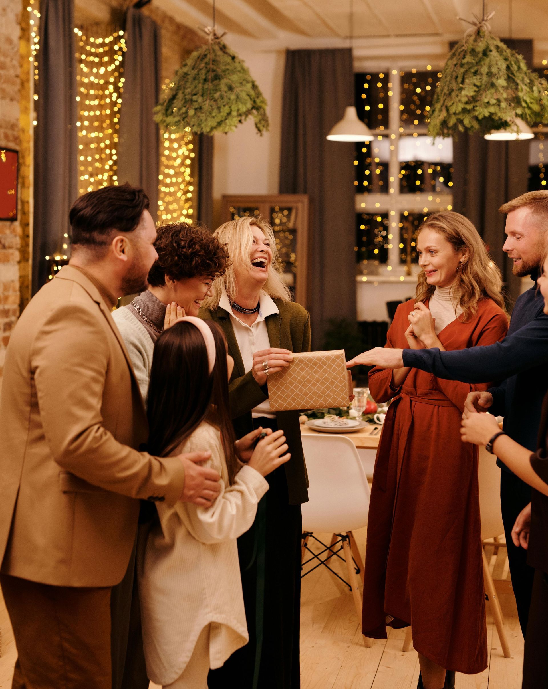 A group of people are standing around a table at a christmas party.