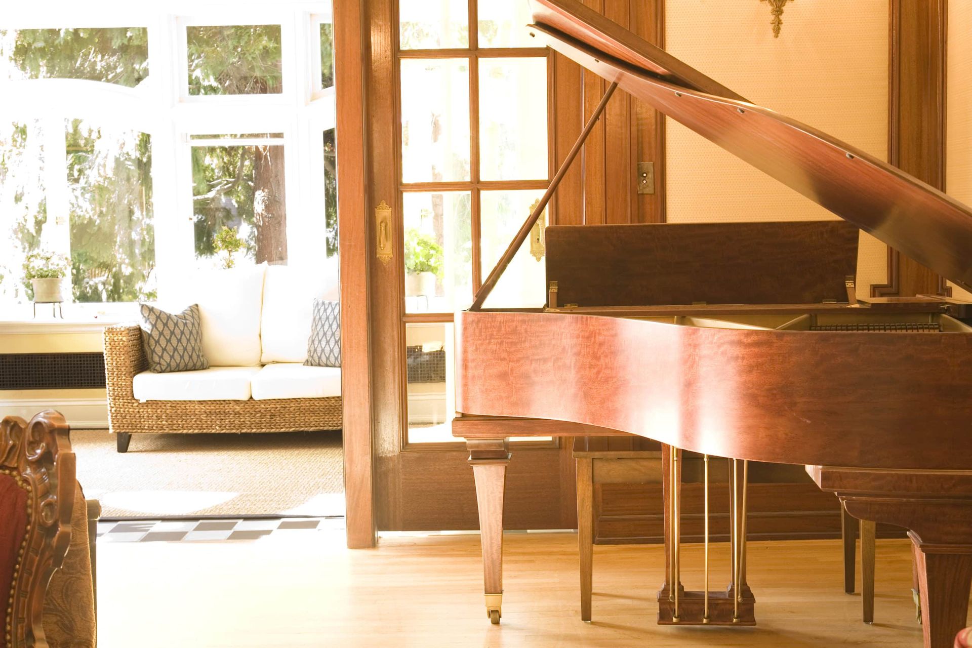 A piano is sitting in a living room next to a couch