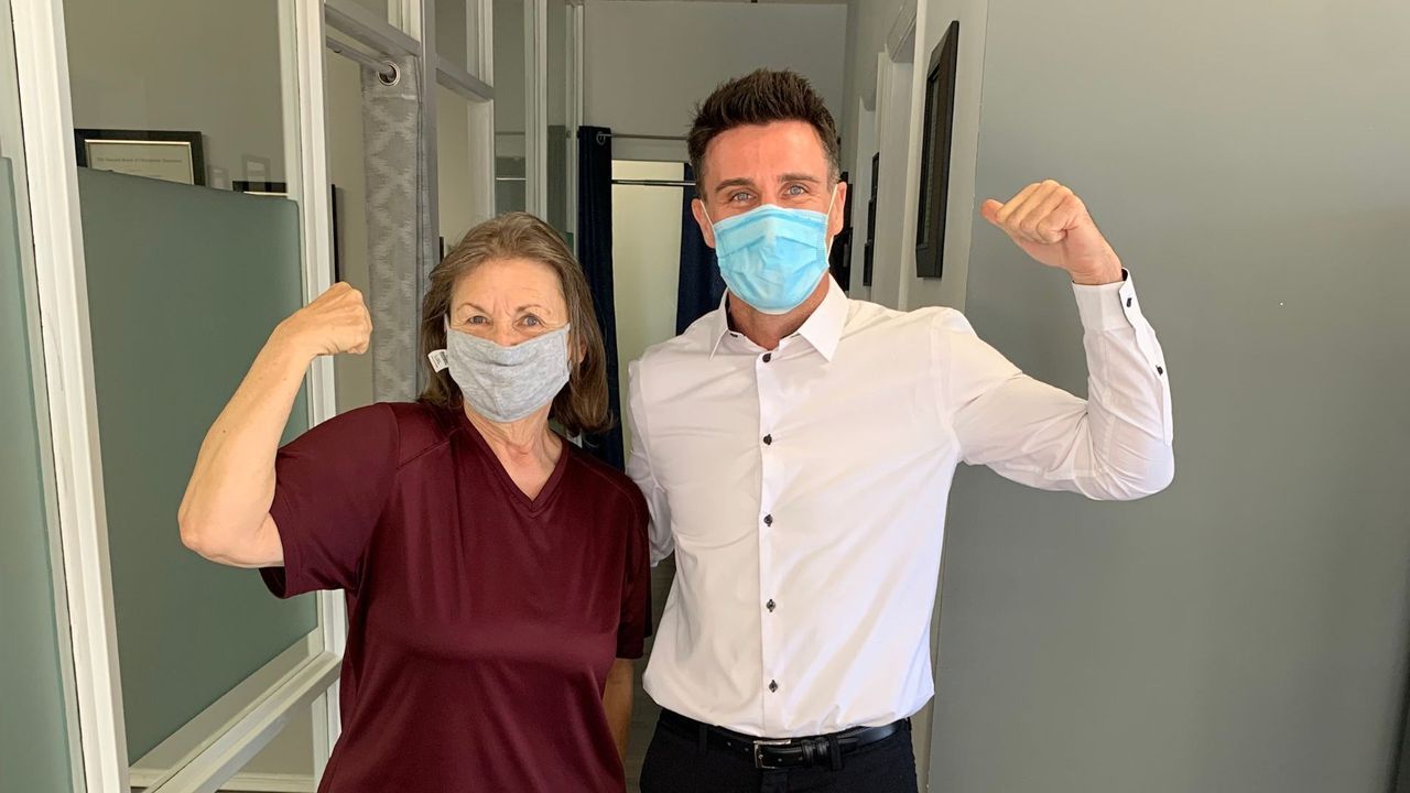 A man and a woman wearing face masks are posing for a picture.