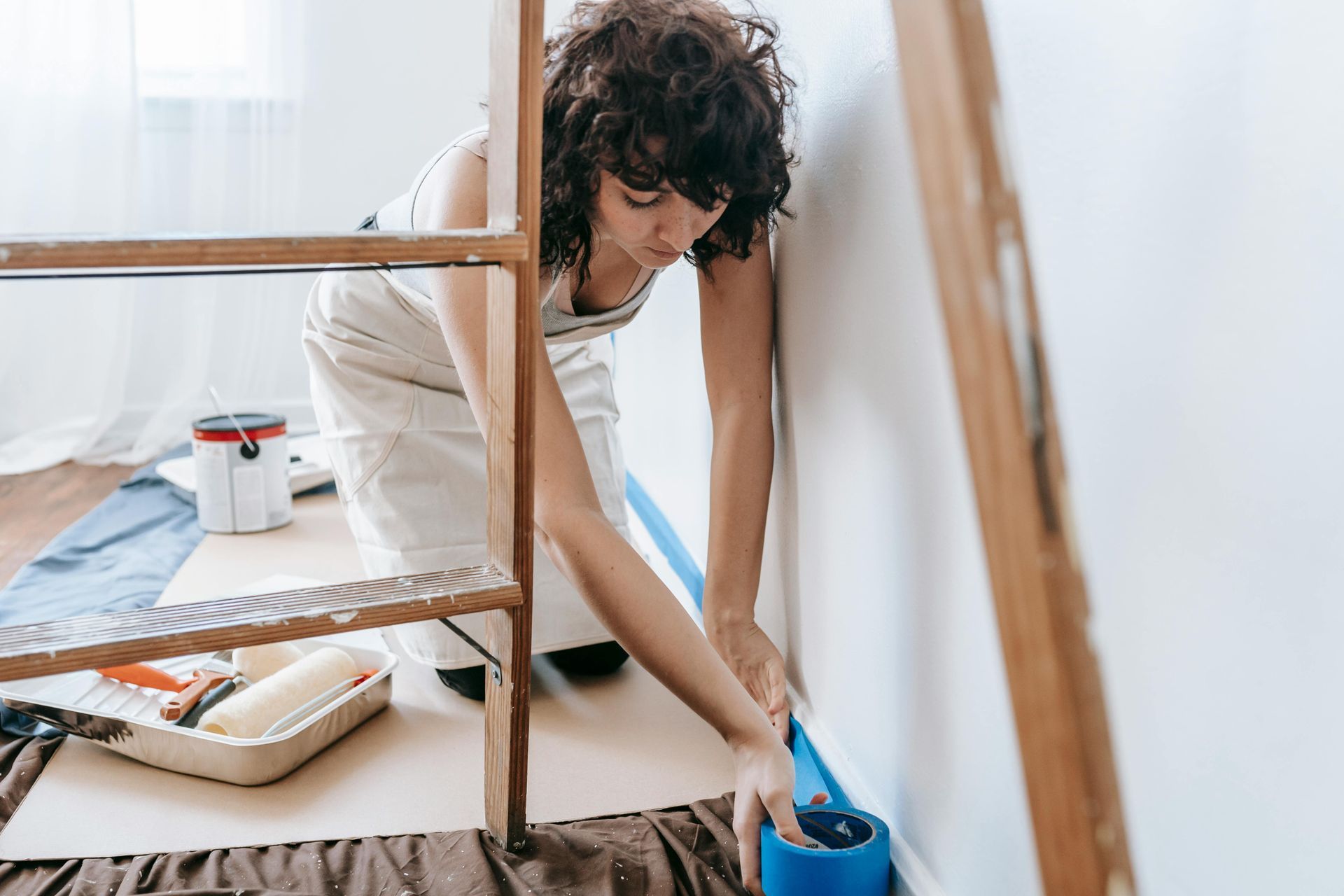 a woman preparing a room to be painted