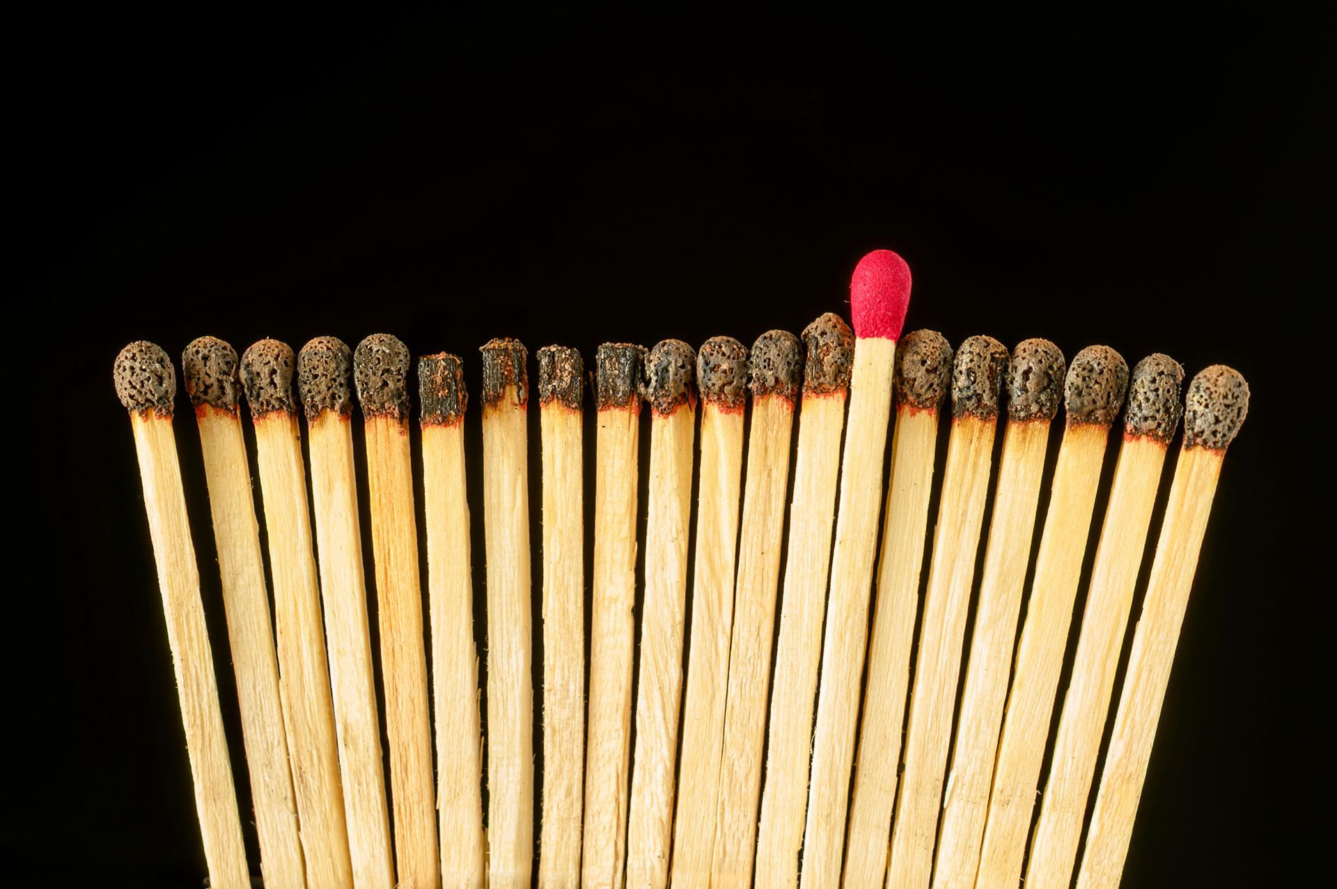Burnt matches lined up with one unlit match sticking out