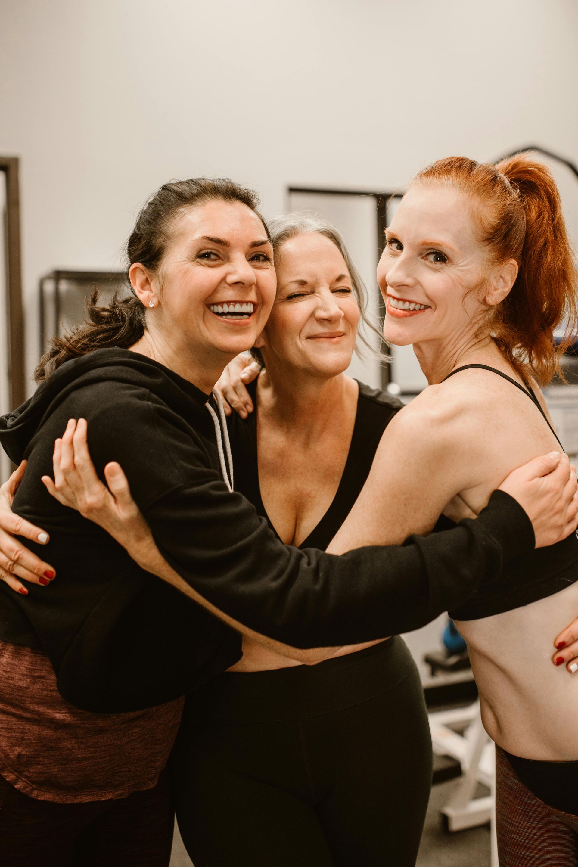 Three women of various ages embrace.