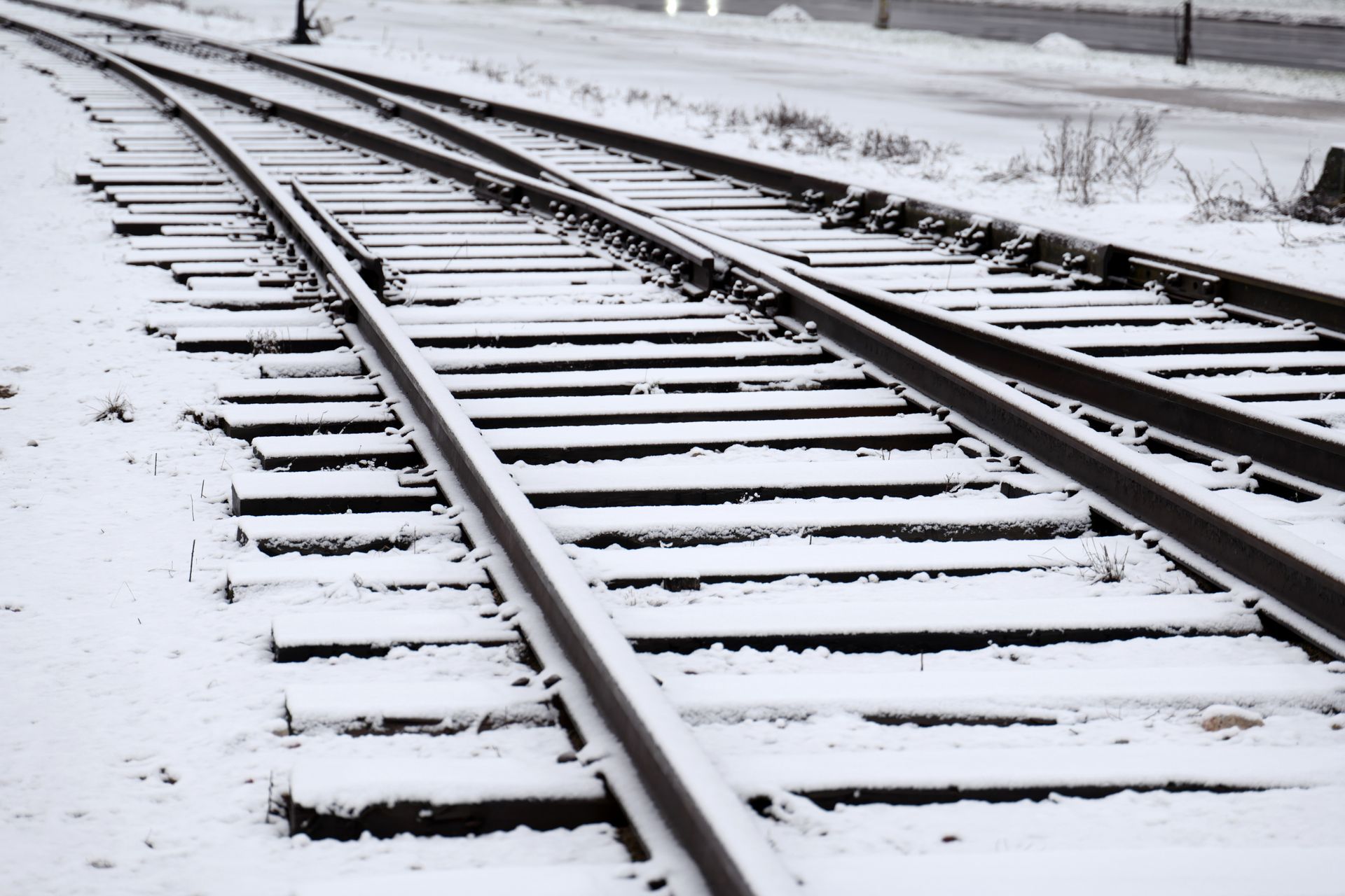 Snow-covered railroad tracks curving through a winter landscape