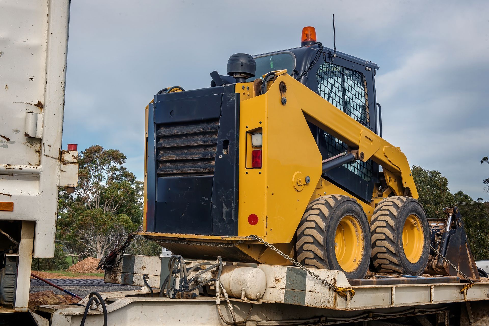 Flatbed tow truck transporting a heavy-duty vehicle during a roadside recovery. Flatbed tow truck transporting a heavy-duty vehicle during a roadside recovery.