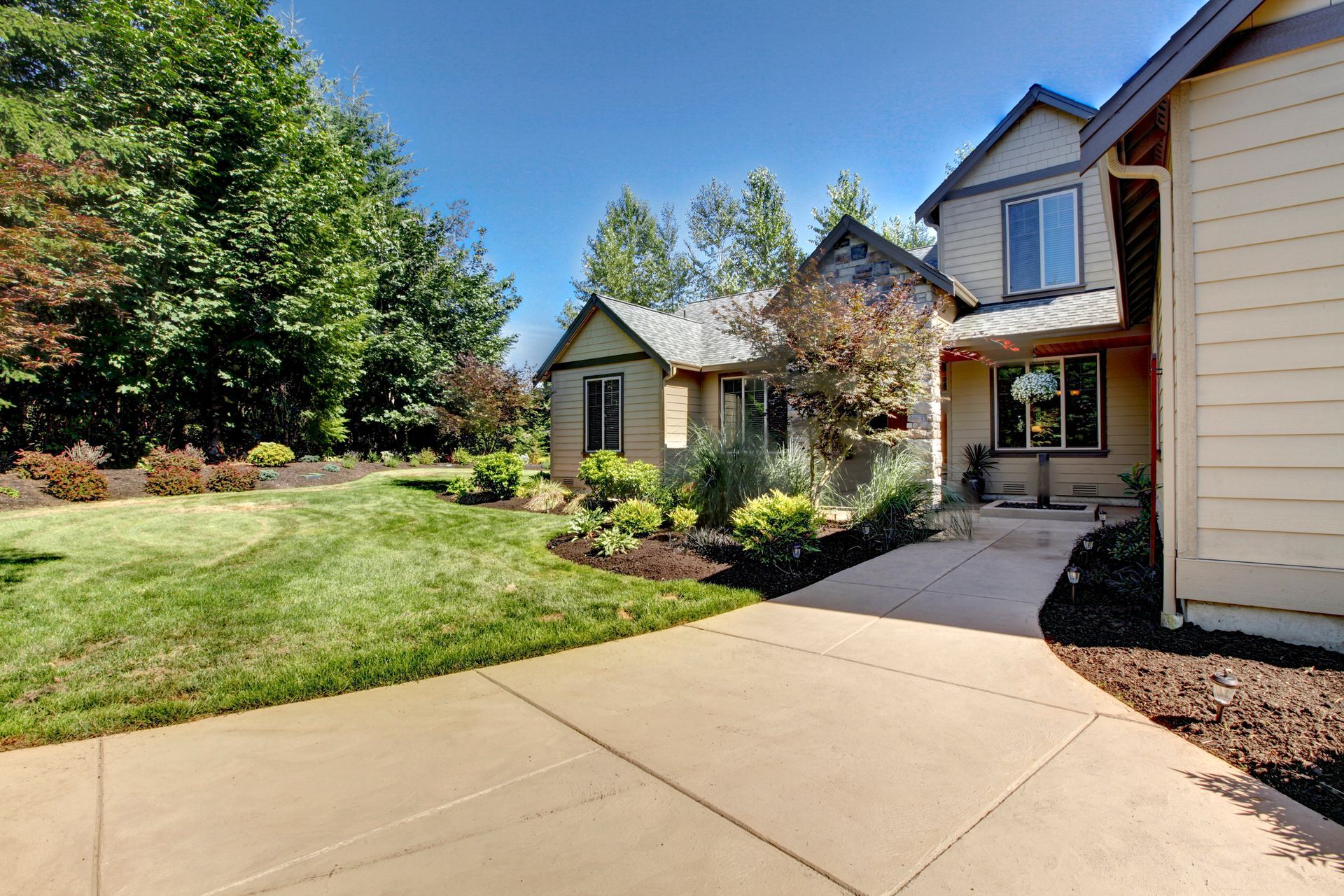 Exterior of a two-story house with a concrete walkway and attractive landscape design. Exterior of a two-story house with a concrete walkway and attractive landscape design.