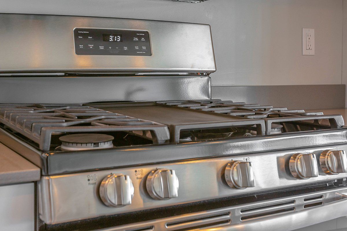 A stainless steel stove top oven is sitting on top of a counter in a kitchen.