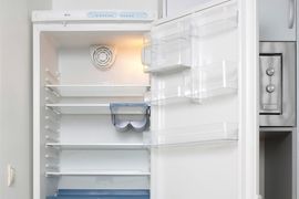 The inside of an empty refrigerator with the door open.