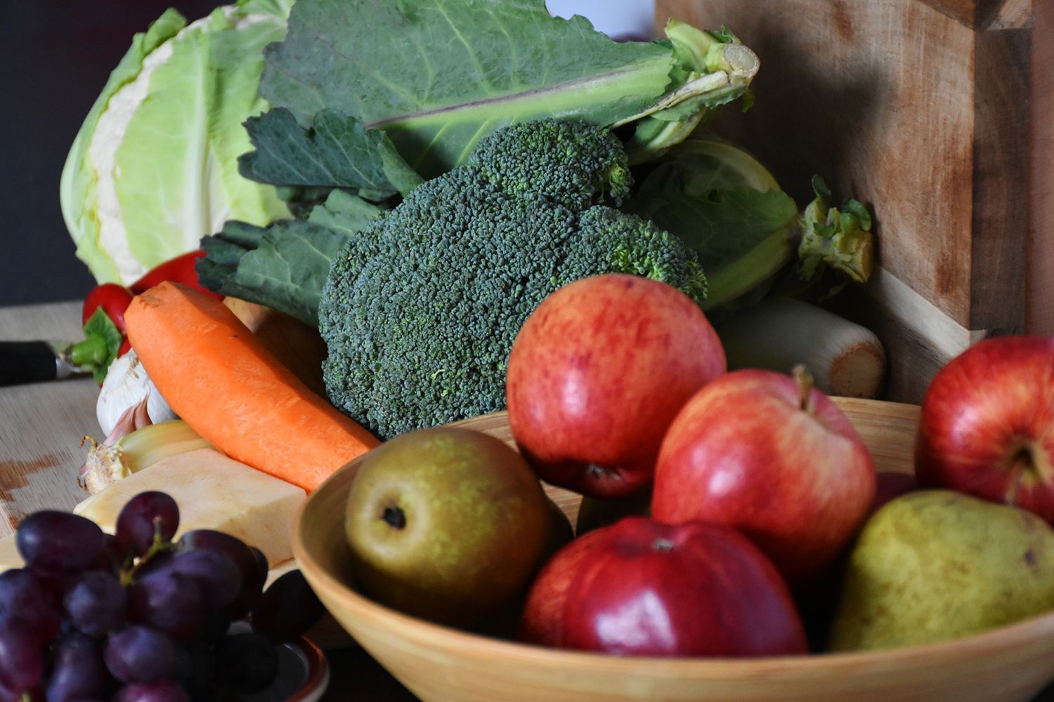 A bowl of fruit and vegetables on a table.