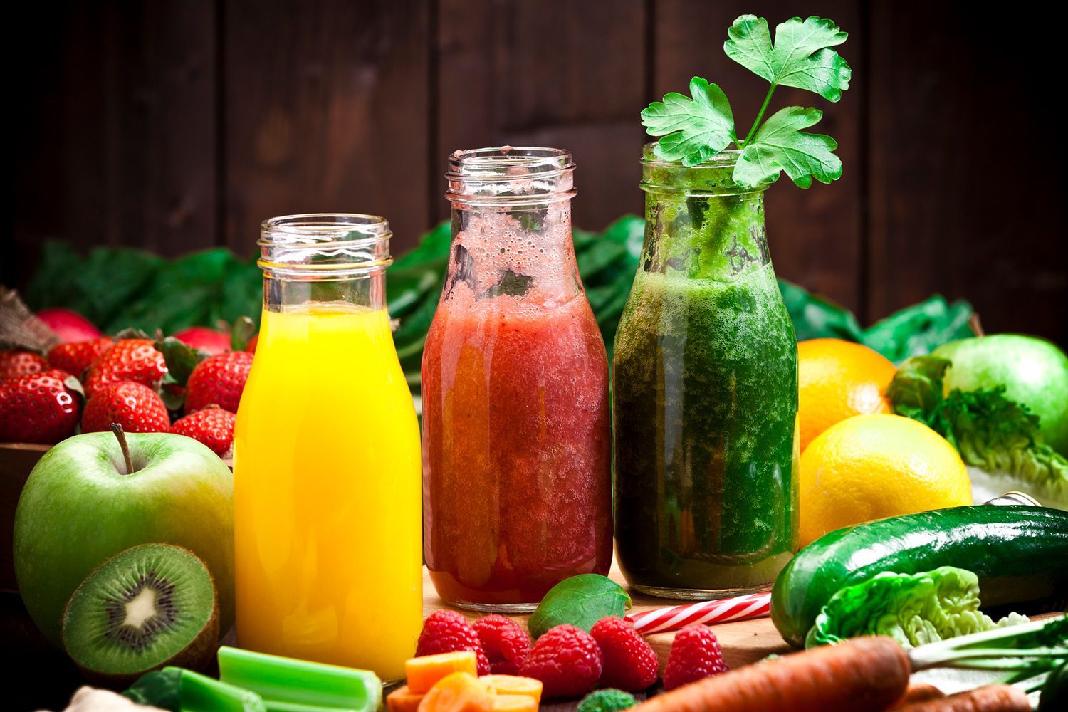 There are many different types of juices and fruits on the table.