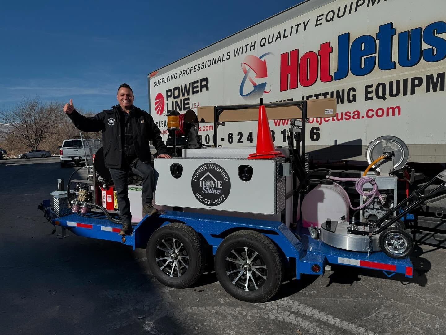 A Home Shine Technician is standing next to a trailer that says hot jets