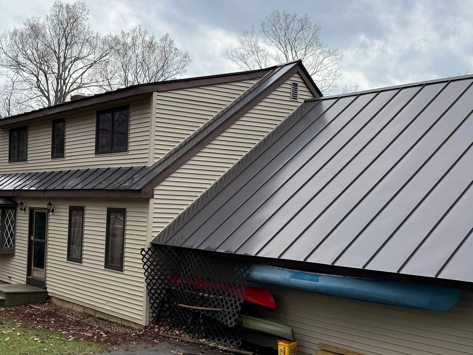 A house with a metal roof and kayaks in the garage cleaned by Home Shine
