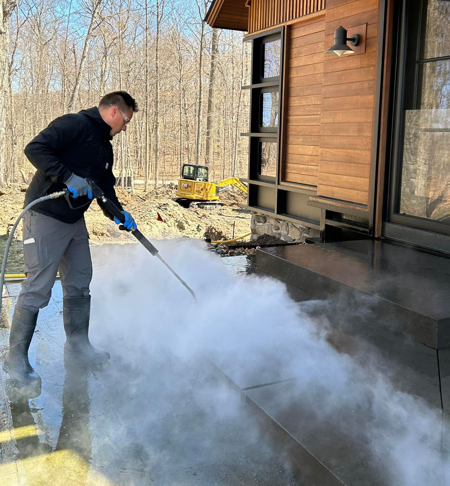 A Home Shine Technician is using a high pressure washer to clean a patio.