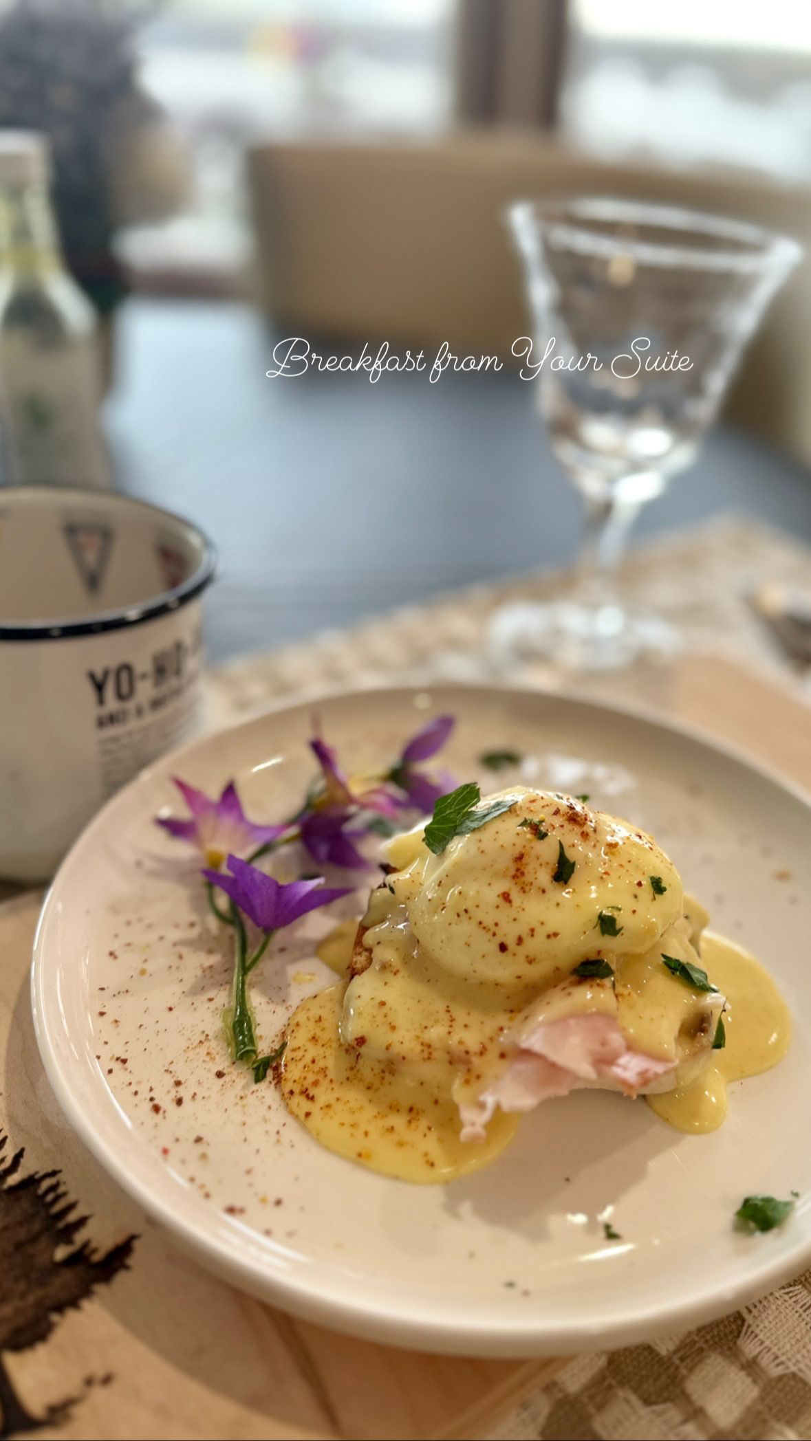 A plate of food with a glass of wine on a table.