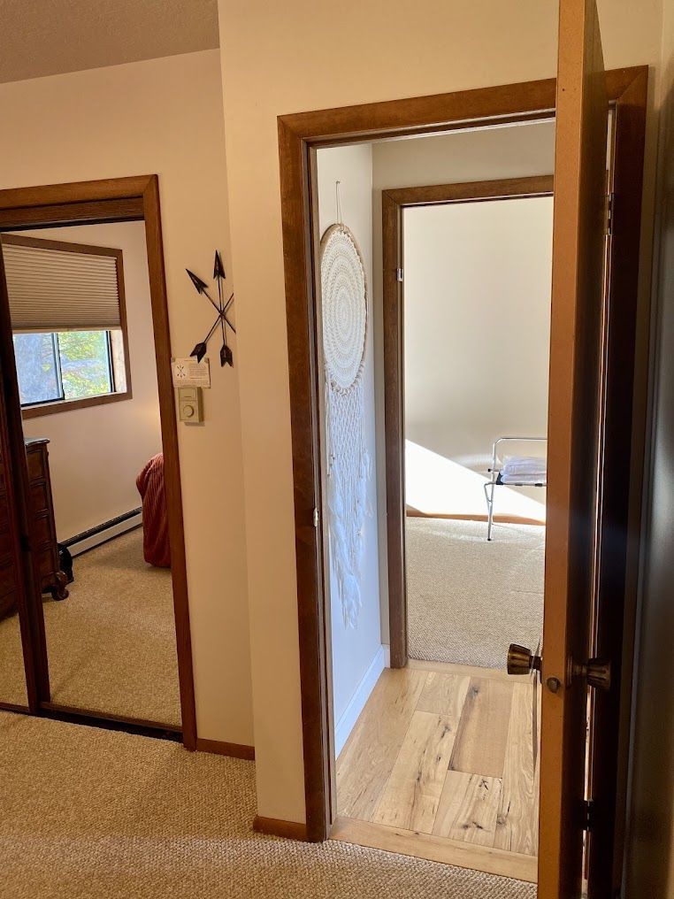 A hallway leading to a bedroom with a dream catcher on the wall