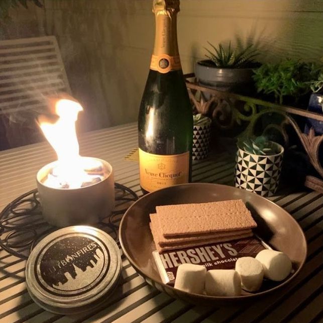 A bottle of champagne sits next to a plate of s'mores and a hershey 's bar