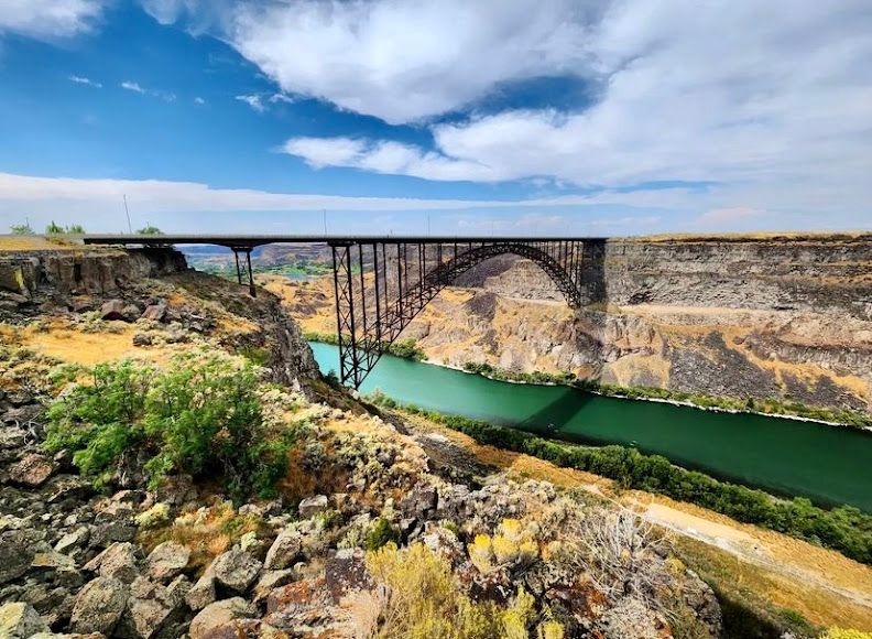 A bridge over a river in the middle of a canyon.