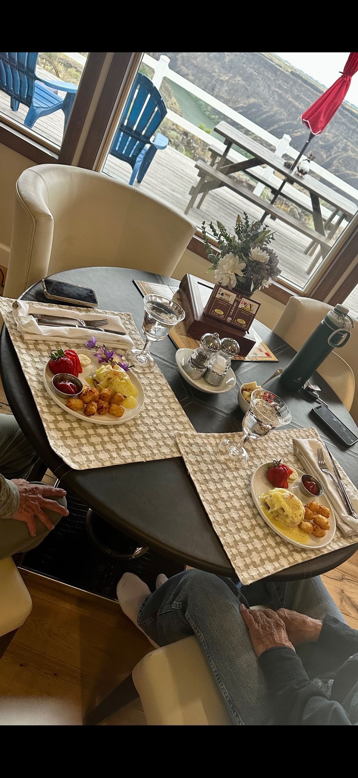 A table set with food and placemats in a dining room with a person sitting at the table.