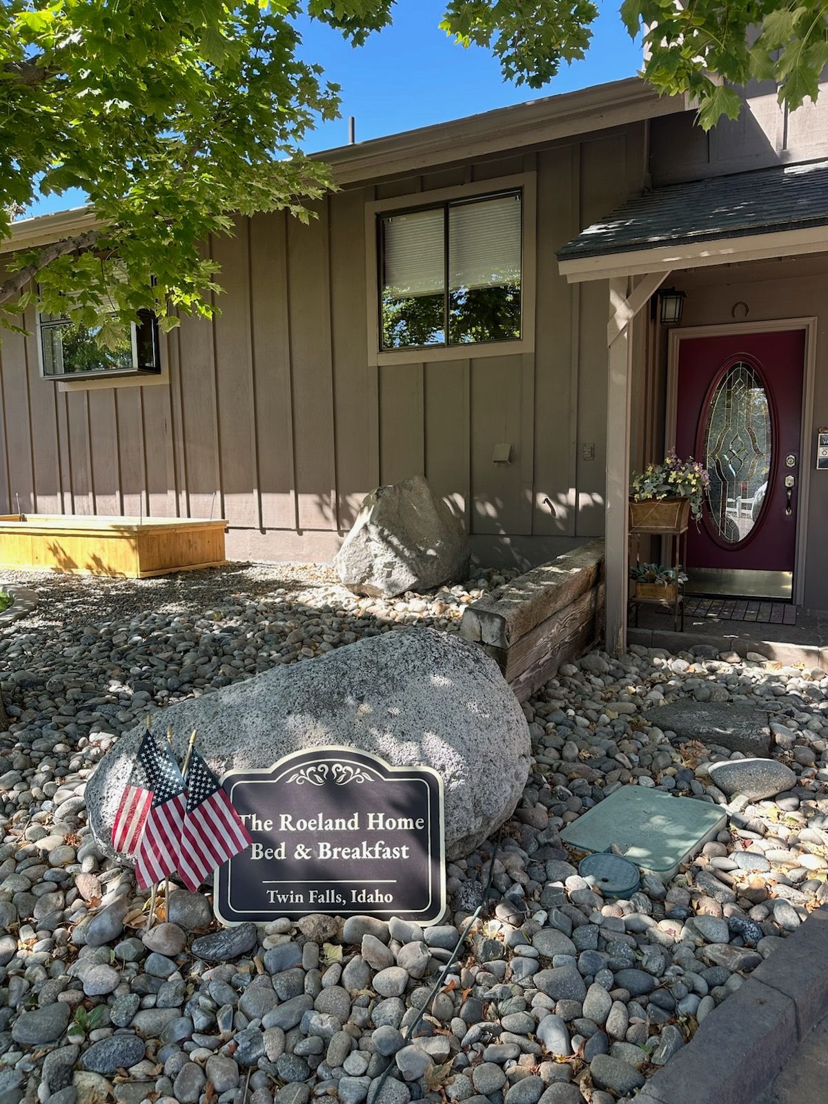 B&B entrance: beige building, red door, sign 