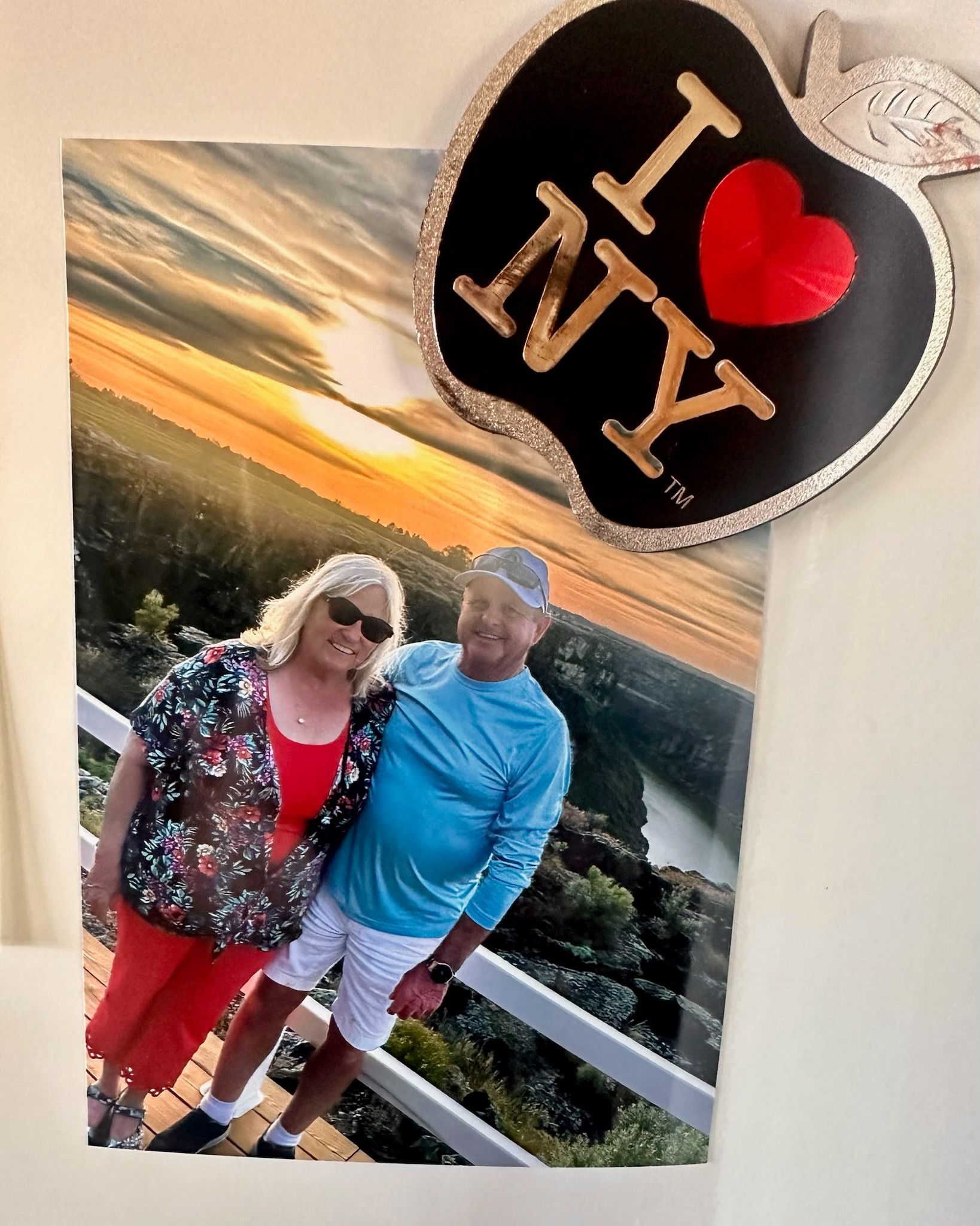 Couple posing on a balcony, with a scenic sunset view. An 