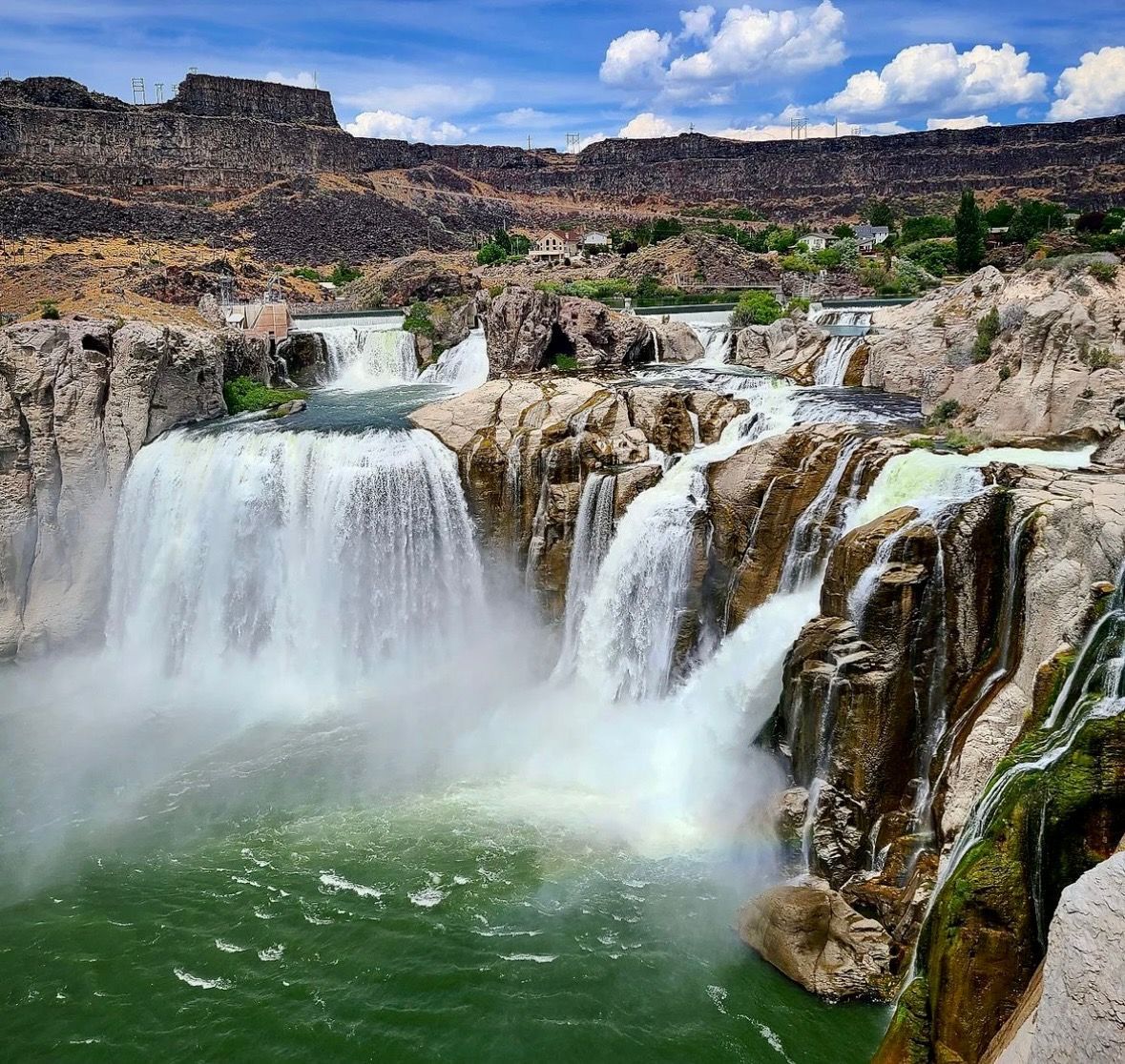 A waterfall in the middle of a river surrounded by rocks
