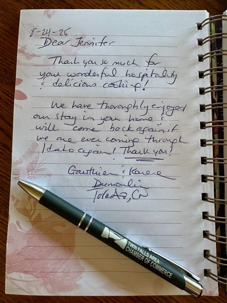 Handwritten thank you note on a spiral notebook, with a pen.
