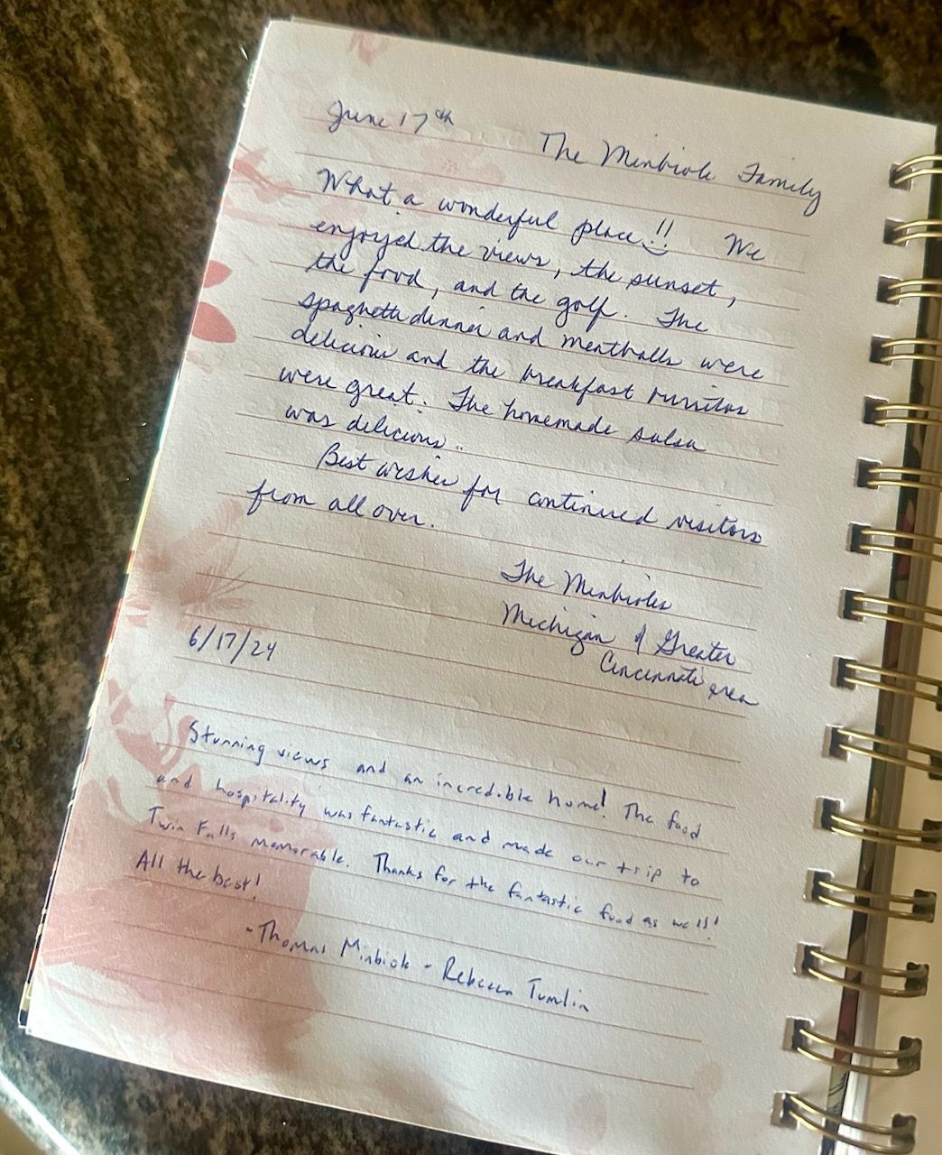 A notebook with writing on it is sitting on a table.