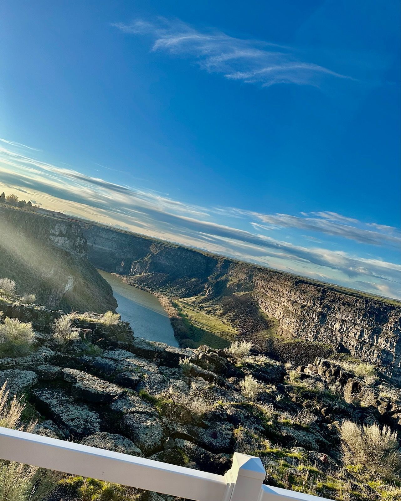 A view of a river going through a canyon from a balcony.