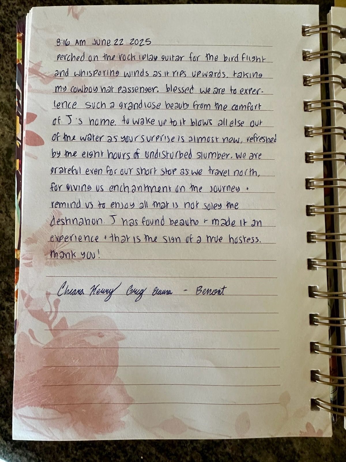 A spiral-bound notebook with handwritten text on a white page, dated 2023, with floral patterns on the sides.