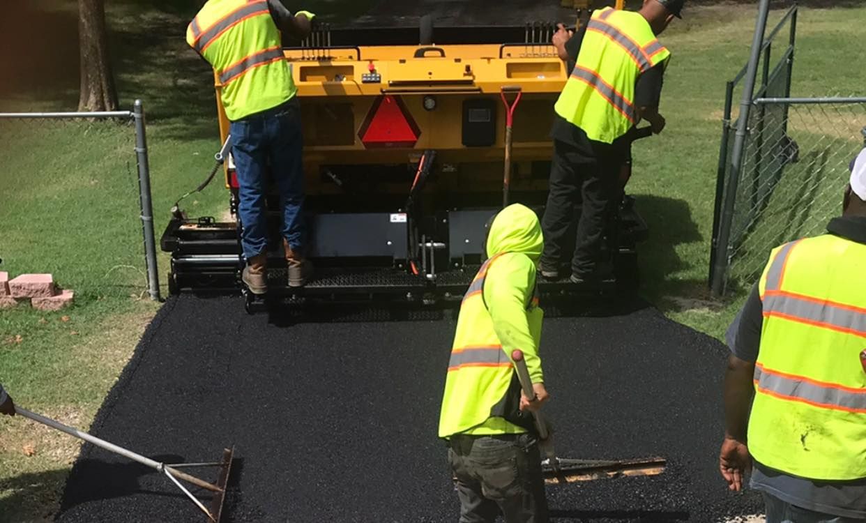 A group of construction workers are working on a road.