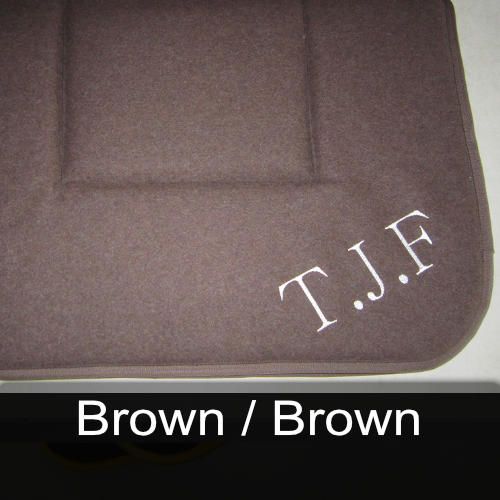 A brown cushion with t.j.f embroidered on it