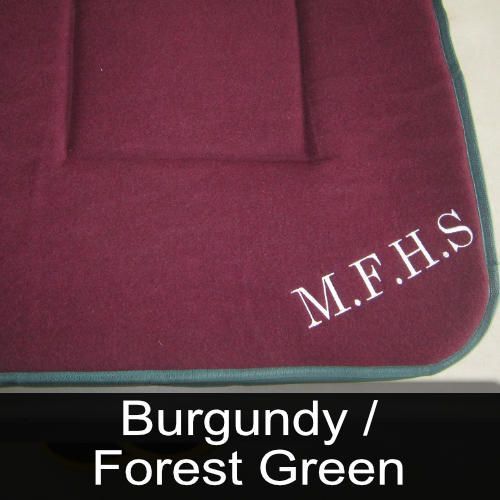 A burgundy / forest green seat cushion with the name m.f.h.s embroidered on it