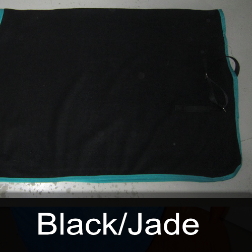 A black / jade blanket is laying on a table