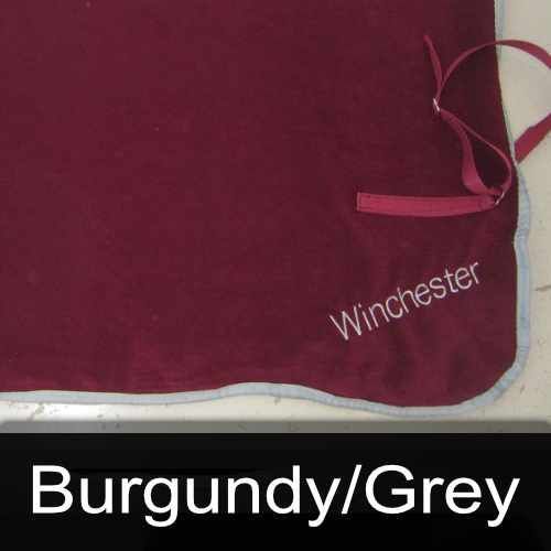 A burgundy blanket with the name winchester embroidered on it
