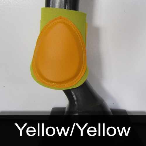 A yellow and green boot is on a horse 's leg.