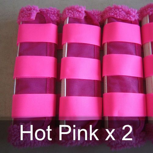A row of hot pink x 2 horse boots on a table