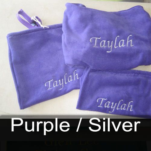 Three purple towels with the names taylah embroidered on them