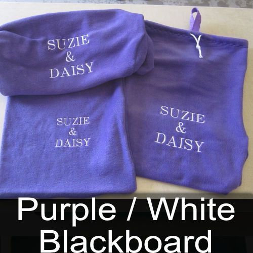 Two purple blankets with the names suzie and daisy embroidered on them